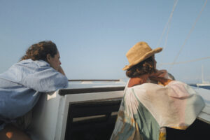 Two girls are watching the horizon while Caliu its sailing on sails. Full day sailing tour in Formentera