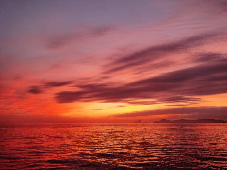 Breathtaking sunset painting the sky in fiery shades of orange and pink over the tranquil sea of Formentera, capturing the island's mesmerizing essence.