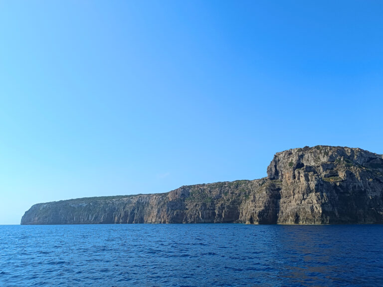 Stunning view of the imposing cliffs of La Mola during a full day sailing tour with Iatu Boats, showcasing Formentera's dramatic and untouched coastline. Discovering the true essence of the island.